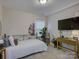A brightly lit bedroom featuring a TV, ceiling light, and small decorative plants at 1209 Gaston Ave, Gastonia, NC 28052