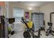 A home exercise room featuring carpeted floors, stationary bike, and decorative armoire at 1209 Gaston Ave, Gastonia, NC 28052