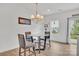 Cozy dining area with a glass table, stylish chairs, chandelier, and natural light from the window at 12110 Chesapeake Mallard Dr, Charlotte, NC 28262