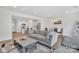 Open concept living room featuring a modern sofa, dining area, and a view into the bright, updated kitchen at 12110 Chesapeake Mallard Dr, Charlotte, NC 28262