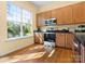Well-lit kitchen with wood cabinets, modern appliances, and a large window with green view at 1219 Crown Vista Dr, Fort Mill, SC 29707