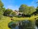 Scenic view of the community pond featuring a fountain surrounded by green grass and trees at 1219 Crown Vista Dr, Fort Mill, SC 29707