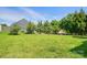 Large, grassy backyard with mature trees, providing privacy and ample space for recreation at 126 W Warfield Dr, Mooresville, NC 28115