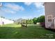 Large backyard featuring a cozy bench swing, providing a peaceful retreat amidst a spacious green lawn and privacy fence at 126 W Warfield Dr, Mooresville, NC 28115
