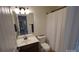 Well-lit bathroom featuring a single vanity, toilet, and shower with a curtain at 126 W Warfield Dr, Mooresville, NC 28115