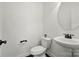 Powder room featuring a pedestal sink, round mirror, and modern black fixtures at 126 W Warfield Dr, Mooresville, NC 28115