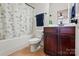 Bathroom with a shower-tub combo, dark wood vanity, and decorative mirror at 126 W Warfield Dr, Mooresville, NC 28115