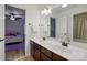 Bright bathroom featuring a double sink vanity, large mirror, and view into adjacent bedroom at 126 W Warfield Dr, Mooresville, NC 28115