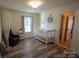 Brightly lit Bedroom with a crib, chair, wood-look floors, and natural light from a window at 126 W Warfield Dr, Mooresville, NC 28115