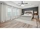 Spacious primary bedroom featuring wood accent wall, tray ceiling, and light-filled windows at 126 W Warfield Dr, Mooresville, NC 28115