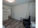 Bedroom with a crib, chair, wood-look floors, and natural light from a window at 126 W Warfield Dr, Mooresville, NC 28115