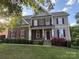 Charming two-story home with stone accents, landscaped yard, and classic red shutters at 126 W Warfield Dr, Mooresville, NC 28115