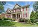 Charming two-story home with stone accents, red shutters and a well-manicured front lawn at 126 W Warfield Dr, Mooresville, NC 28115