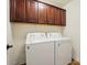 Convenient laundry room featuring a washer and dryer set with dark wood cabinets above at 126 W Warfield Dr, Mooresville, NC 28115