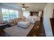 Spacious living room with large windows, plush sofa, open floor plan to the kitchen, and hardwood floors at 126 W Warfield Dr, Mooresville, NC 28115