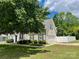 View of charming white home with black shutters, fenced yard and two-car garage at 13241 Woodland Farm Dr, Charlotte, NC 28215