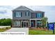 Charming two-story home with stone accents, gray siding, landscaped yard, and welcoming front porch at 1361 Secrest Commons Dr, Monroe, NC 28112