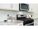 Close-up of a modern gas range and microwave with white backsplash and granite countertops at 1365 Secrest Commons Dr, Monroe, NC 28112