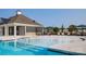 Community pool with zero entry, splash fountains, outdoor seating, and adjacent clubhouse at 1365 Secrest Commons Dr, Monroe, NC 28112