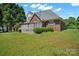 Spacious backyard featuring a brick home with white deck, green lawn, and shade trees at 14340 Kendalton Meadow Dr, Mint Hill, NC 28227