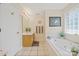 Bright bathroom featuring a soaking tub and a single vanity with plenty of natural light from the window at 14340 Kendalton Meadow Dr, Mint Hill, NC 28227
