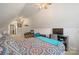 Bedroom in the attic features a bed, desk and ceiling fans at 14340 Kendalton Meadow Dr, Mint Hill, NC 28227