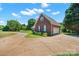 Charming brick home features a well-manicured front yard and circular driveway leading to the garage at 14340 Kendalton Meadow Dr, Mint Hill, NC 28227