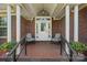 Inviting front porch featuring tile flooring, comfortable seating, and a brick surround at 14340 Kendalton Meadow Dr, Mint Hill, NC 28227
