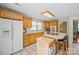 Classic kitchen features wooden cabinets, white appliances and a large island at 14340 Kendalton Meadow Dr, Mint Hill, NC 28227