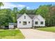 Bright, modern white farmhouse with an expansive driveway and lush green lawn at 184 Quiet Cove Rd, Mooresville, NC 28117