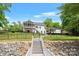 Exterior view of a lakefront property, featuring a dock, boat, backyard, porch, and outdoor structure at 184 Quiet Cove Rd, Mooresville, NC 28117