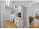 Functional laundry room with wood floors, washer, dryer, sink, utility cabinet, and access to other rooms at 184 Quiet Cove Rd, Mooresville, NC 28117