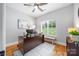 Bright office features a ceiling fan, modern desk, and a window overlooking the landscaped yard at 184 Quiet Cove Rd, Mooresville, NC 28117