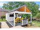 Outdoor structure with vaulted ceiling, black and yellow furniture, TV, and views of the lake at 184 Quiet Cove Rd, Mooresville, NC 28117