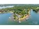 Wide aerial view of waterfront real estate, featuring docks and a private beach at 19523 Sunnypoint Ct, Cornelius, NC 28031