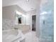 Spacious bathroom showcasing marble tile, walk-in shower, large tub, and double vanity at 19523 Sunnypoint Ct, Cornelius, NC 28031