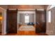 Bonus room with hardwood floors, stylish barn doors, a colorful rug, and natural light at 19523 Sunnypoint Ct, Cornelius, NC 28031