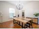Bright dining room with hardwood floors, modern chandelier, and a wooden dining table at 19523 Sunnypoint Ct, Cornelius, NC 28031