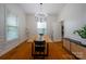 Bright dining room with hardwood floors, modern chandelier, and a wooden dining table at 19523 Sunnypoint Ct, Cornelius, NC 28031