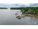 Waterfront home and dock with multiple boat slips on a serene lake surrounded by lush greenery at 19523 Sunnypoint Ct, Cornelius, NC 28031