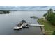 Aerial view of boat docks along a lake with boats, surrounded by lush greenery at 19523 Sunnypoint Ct, Cornelius, NC 28031