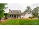 Beautiful white home showcasing a manicured lawn and inviting front porch at 19523 Sunnypoint Ct, Cornelius, NC 28031