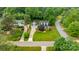 Aerial view of a charming home with a manicured lawn and mature landscaping, surrounded by lush green trees at 19523 Sunnypoint Ct, Cornelius, NC 28031