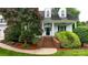 Charming home entrance featuring brick steps, classic columns, and landscaped garden beds at 19523 Sunnypoint Ct, Cornelius, NC 28031