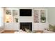 Bright living room with built-in shelving, a fireplace, and hardwood floors at 19523 Sunnypoint Ct, Cornelius, NC 28031