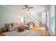 Inviting living room with stairs, hardwood floors, a comfortable sofa, and lots of natural light at 19523 Sunnypoint Ct, Cornelius, NC 28031