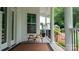 Covered front porch with a picnic table and lush green plants at 19523 Sunnypoint Ct, Cornelius, NC 28031