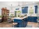 Open kitchen with blue cabinets, island with counter seating, and dining area with wooden table at 1994 Hollybrook Ln # 17, Lancaster, SC 29720