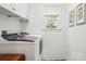 Bright laundry room with modern washer and dryer, white cabinetry, and a window at 1994 Hollybrook Ln # 17, Lancaster, SC 29720