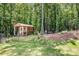 Quaint shed in a serene wooded area with lush greenery, a seating area, and an American flag at 1994 Hollybrook Ln # 17, Lancaster, SC 29720